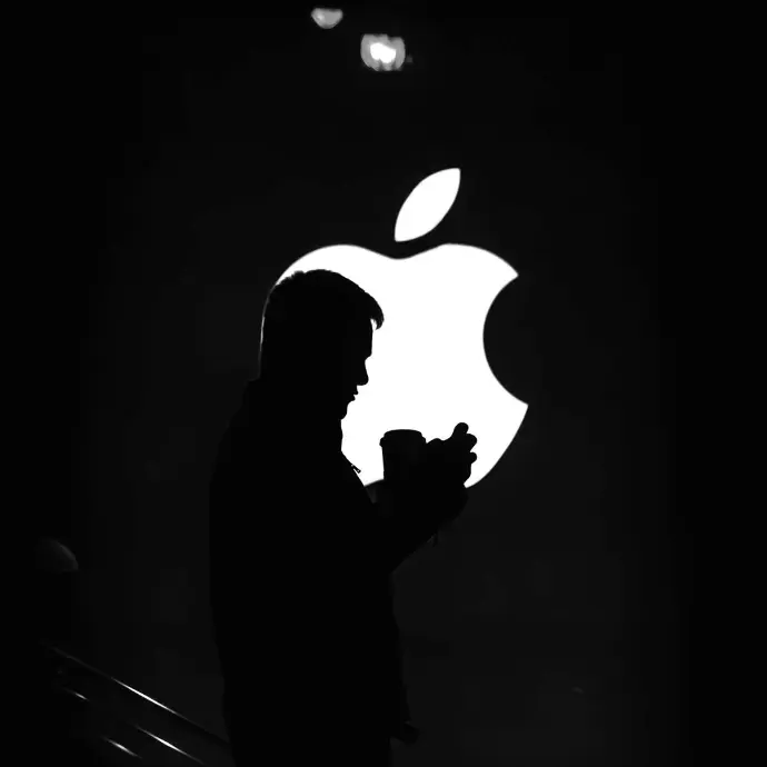 A person standing in front of Apple logo